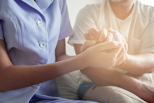 Close up shot of nurse holding the hand of a patient